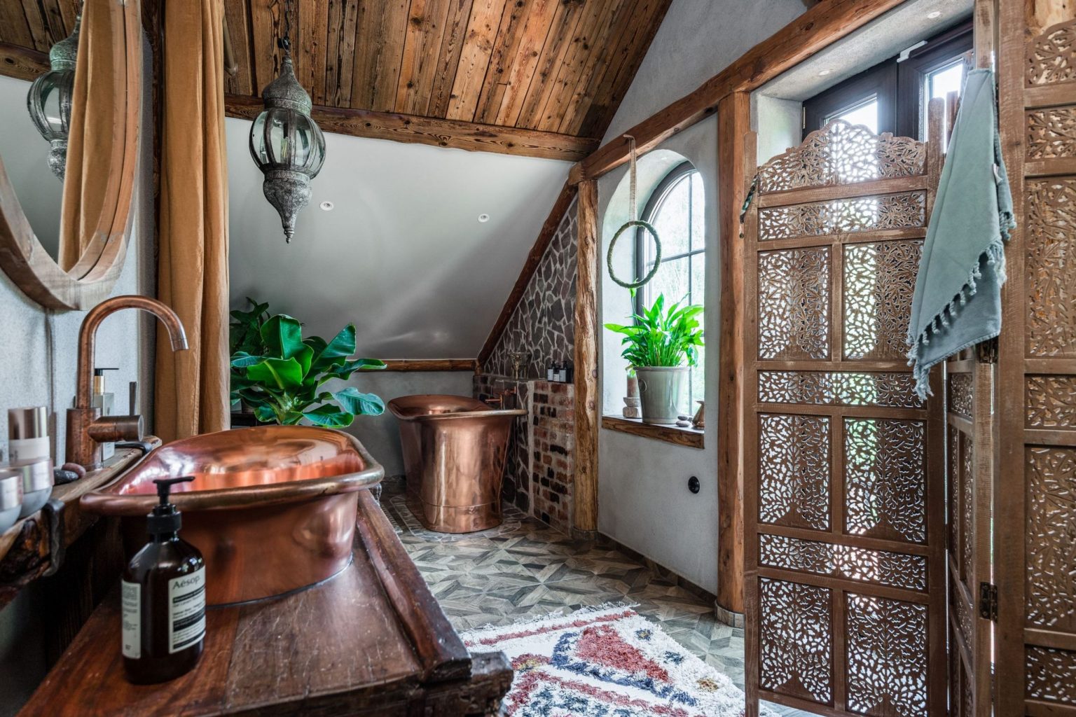 salle de bain avec fenêtres et baignoire en cuivre