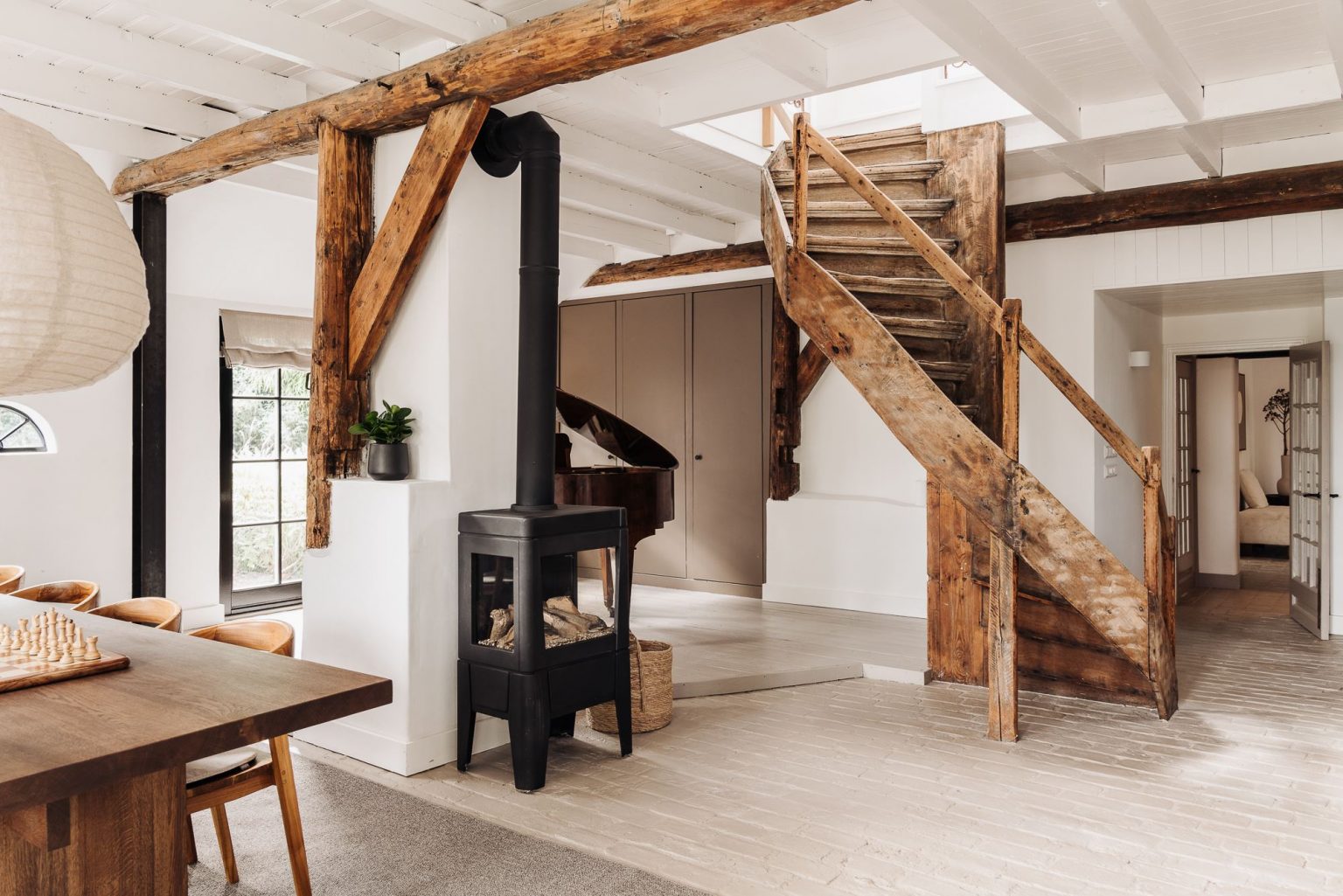salon avec poêle et escalier en bois ancien