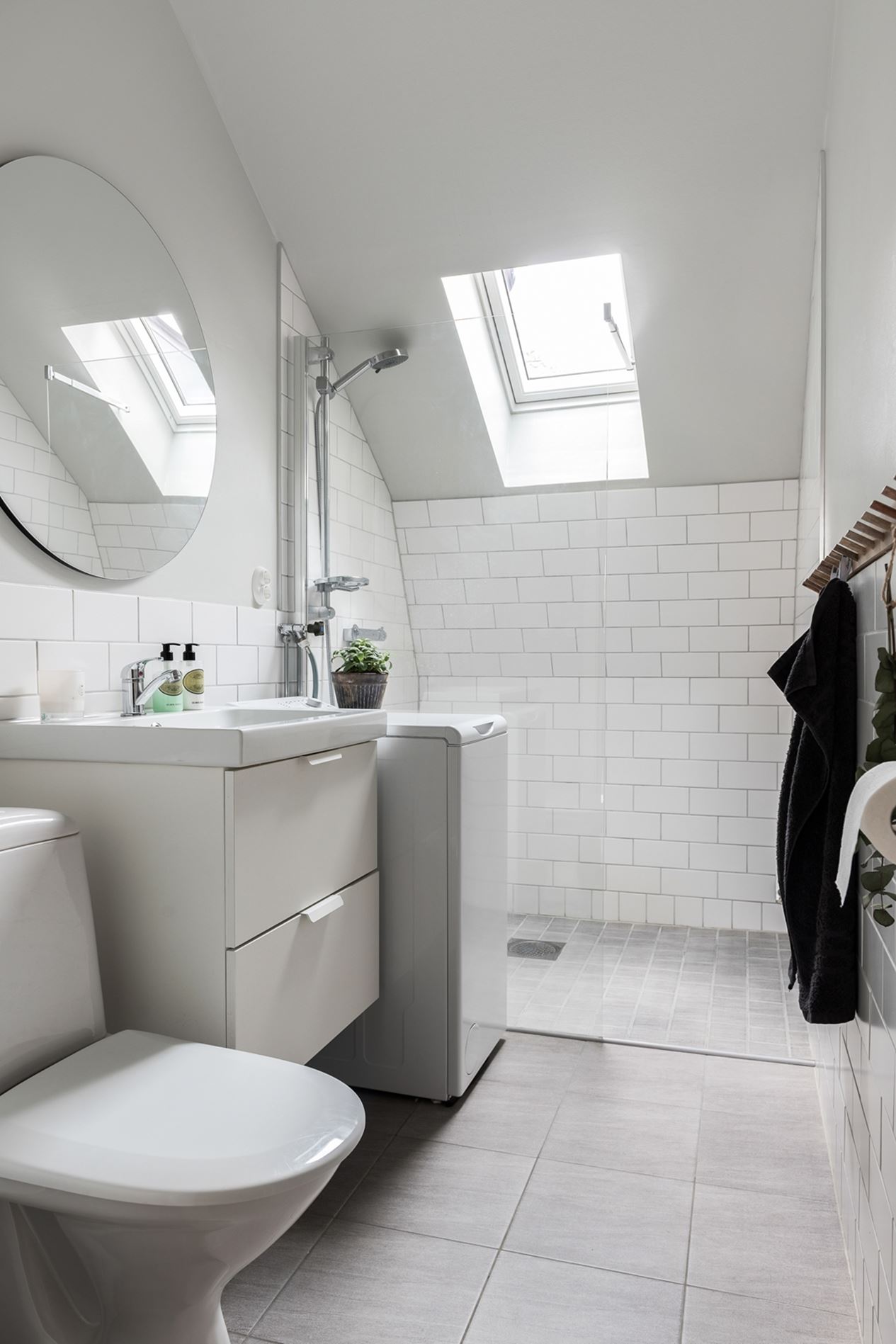 salle de bain design blanche avec fenêtre de toit