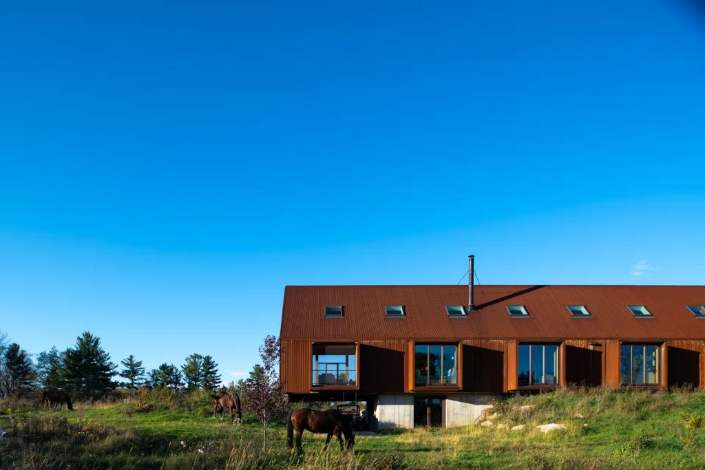 Une maison perchée sur une colline rocheuse inspirée des granges