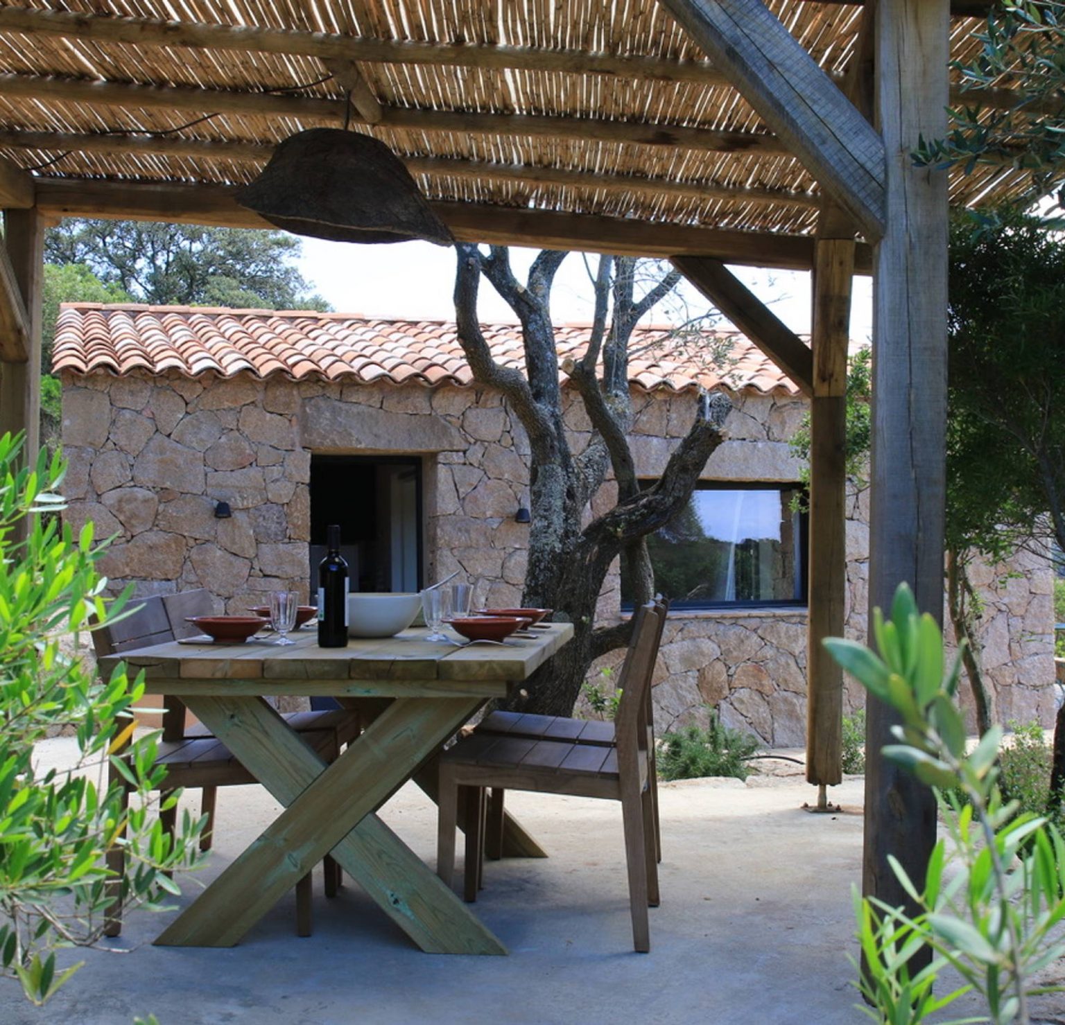terrasse avec pergola bois petite maison en pierres Corse