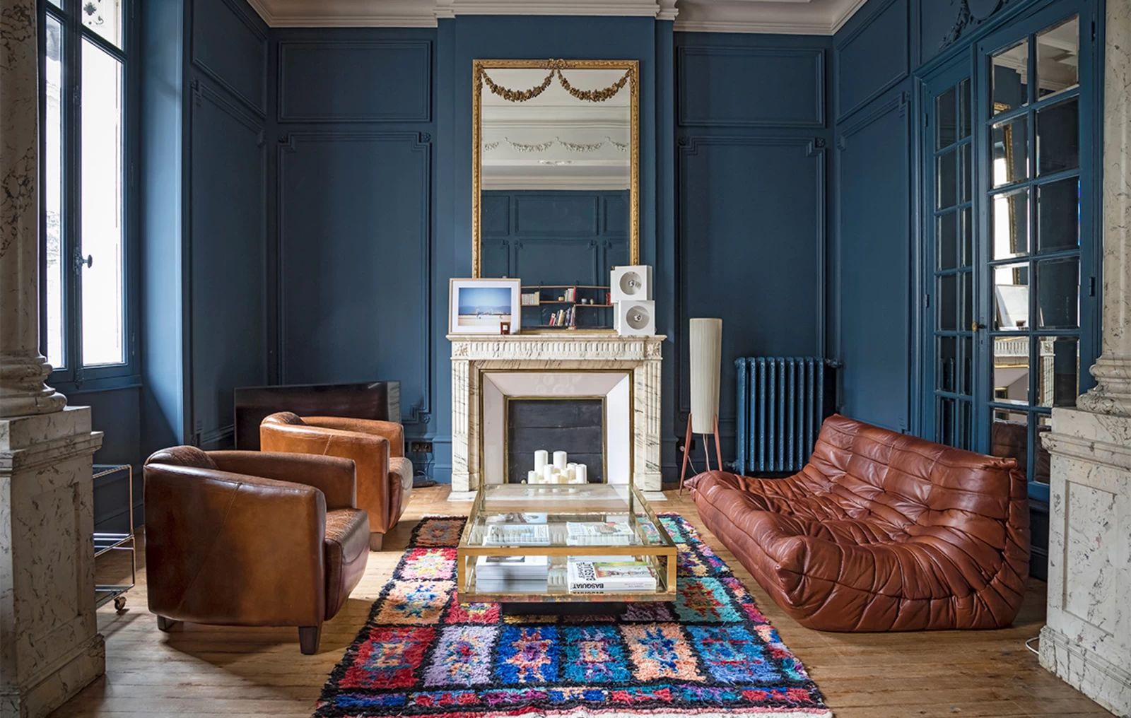 salon mur bleu avec canapé Togo en cuir vintage