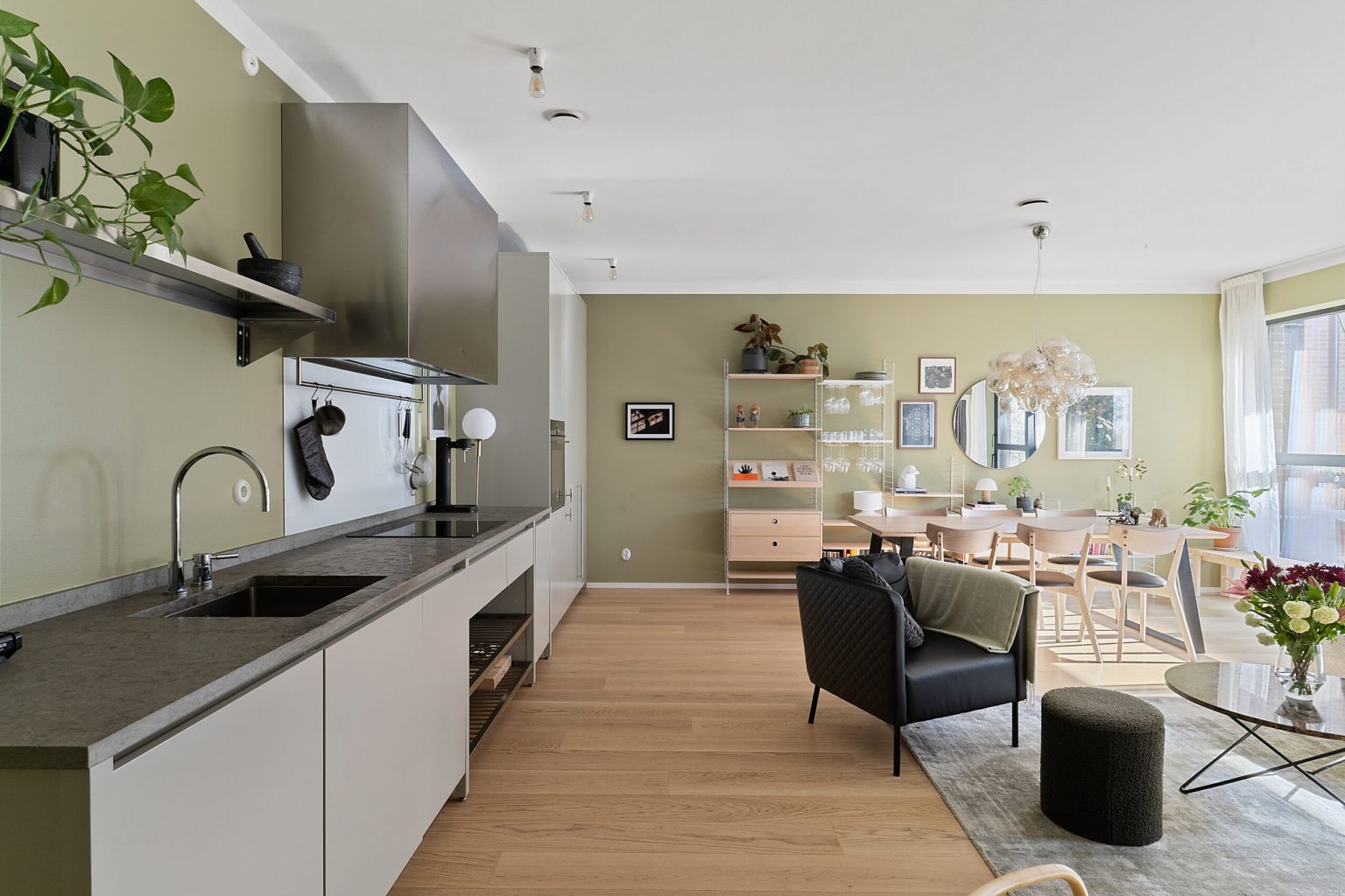 salon avec cuisine ouverte murs verts décoration moderne