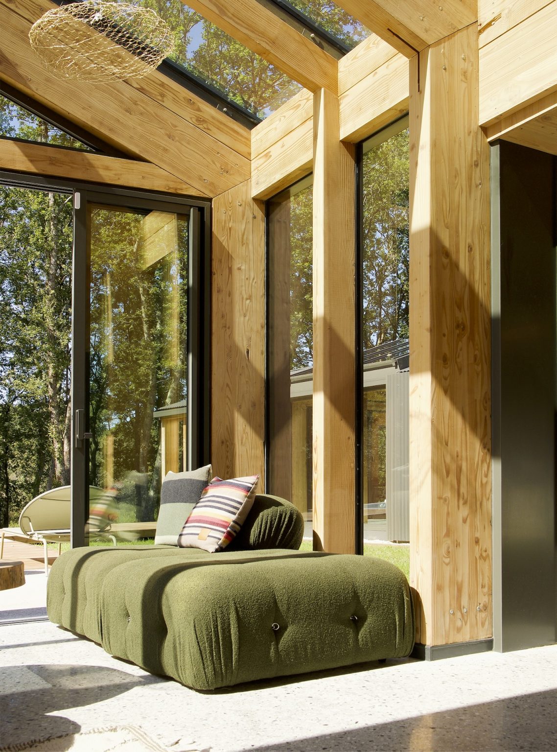 Une immense maison en bois au cœur d’un parc forestier