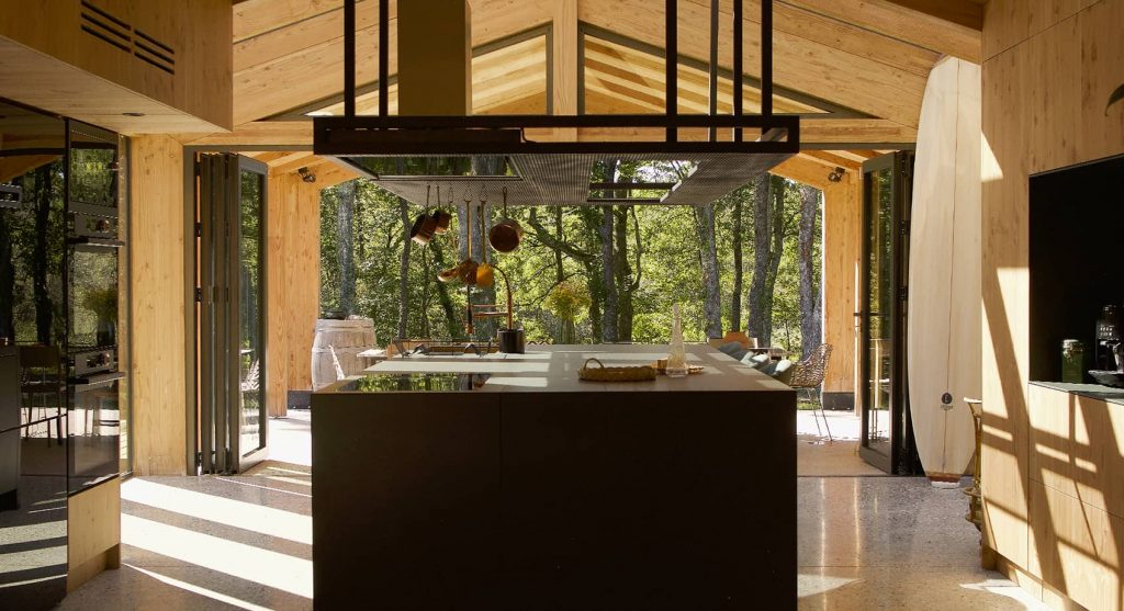Une immense maison en bois au cœur d’un parc forestier