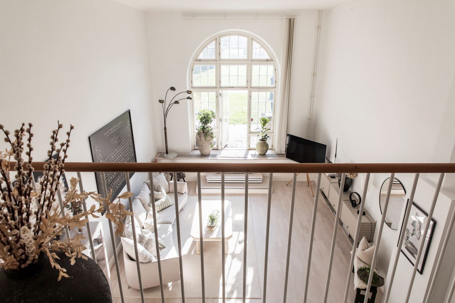 salon avec fenêtre cintrée et mezzanine appartement en duplex décoration scandinave naturelle