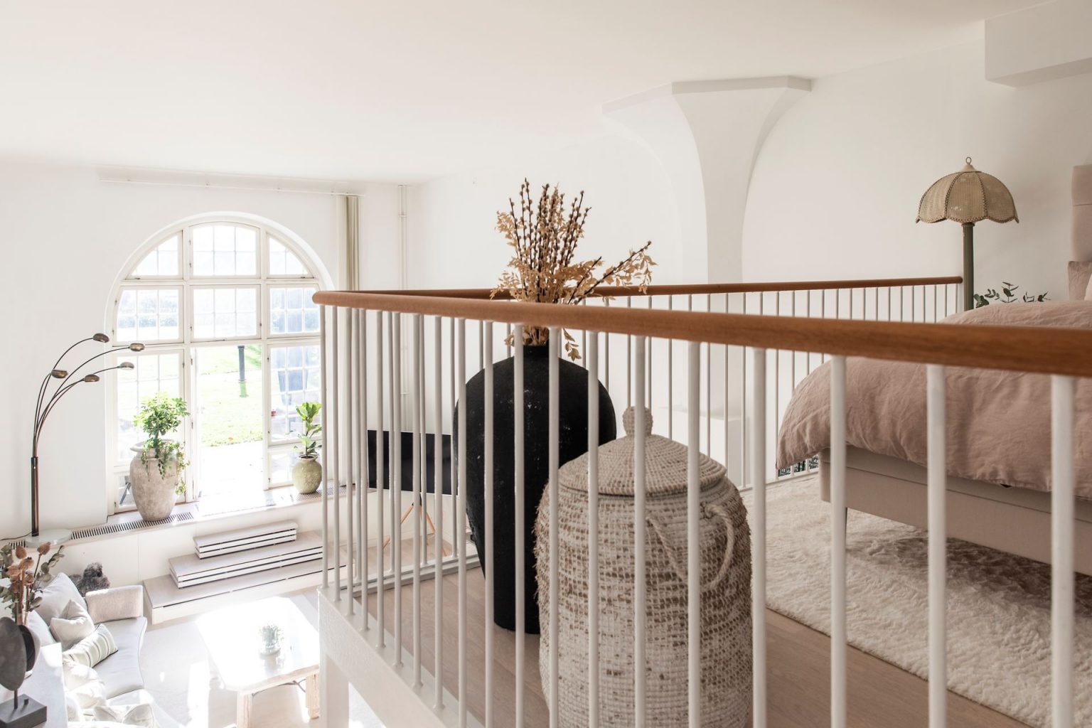 salon avec fenêtre cintrée et chambre en mezzanine appartement en duplex décoration scandinave naturelle