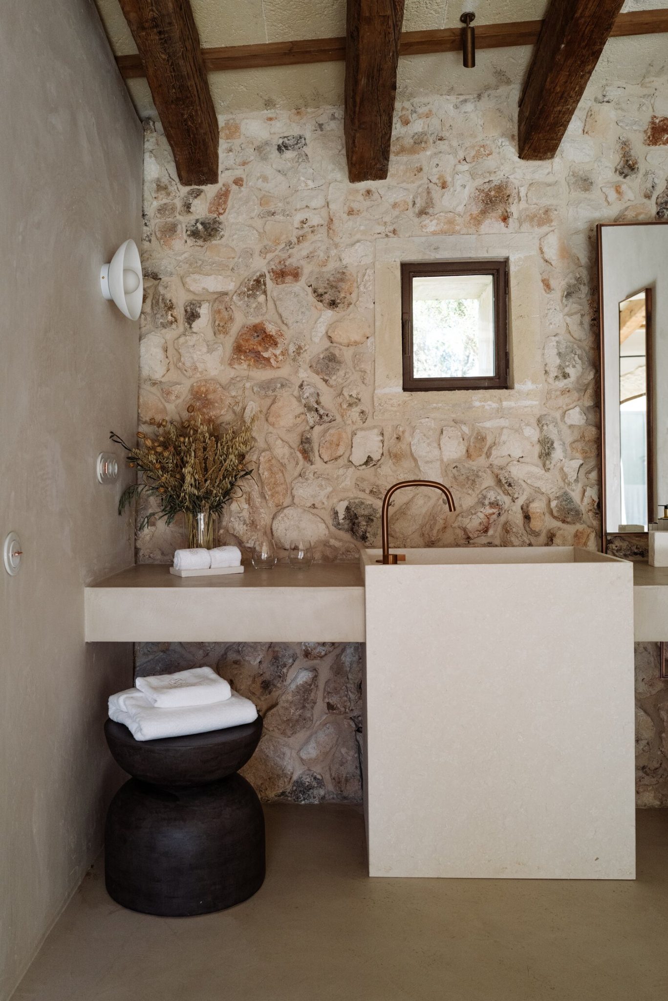 salle de bain avec poutres mur pierre