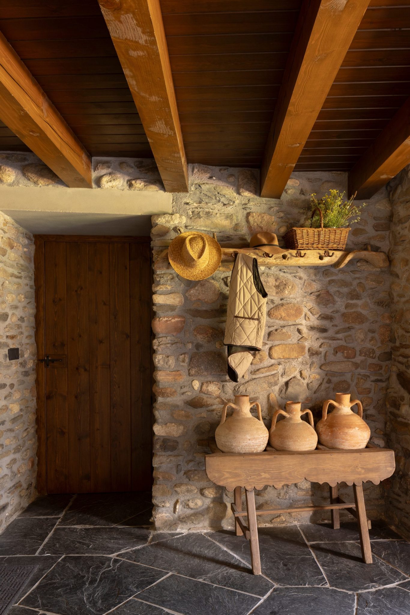 entrée avec poutres et murs de pierres anciennes