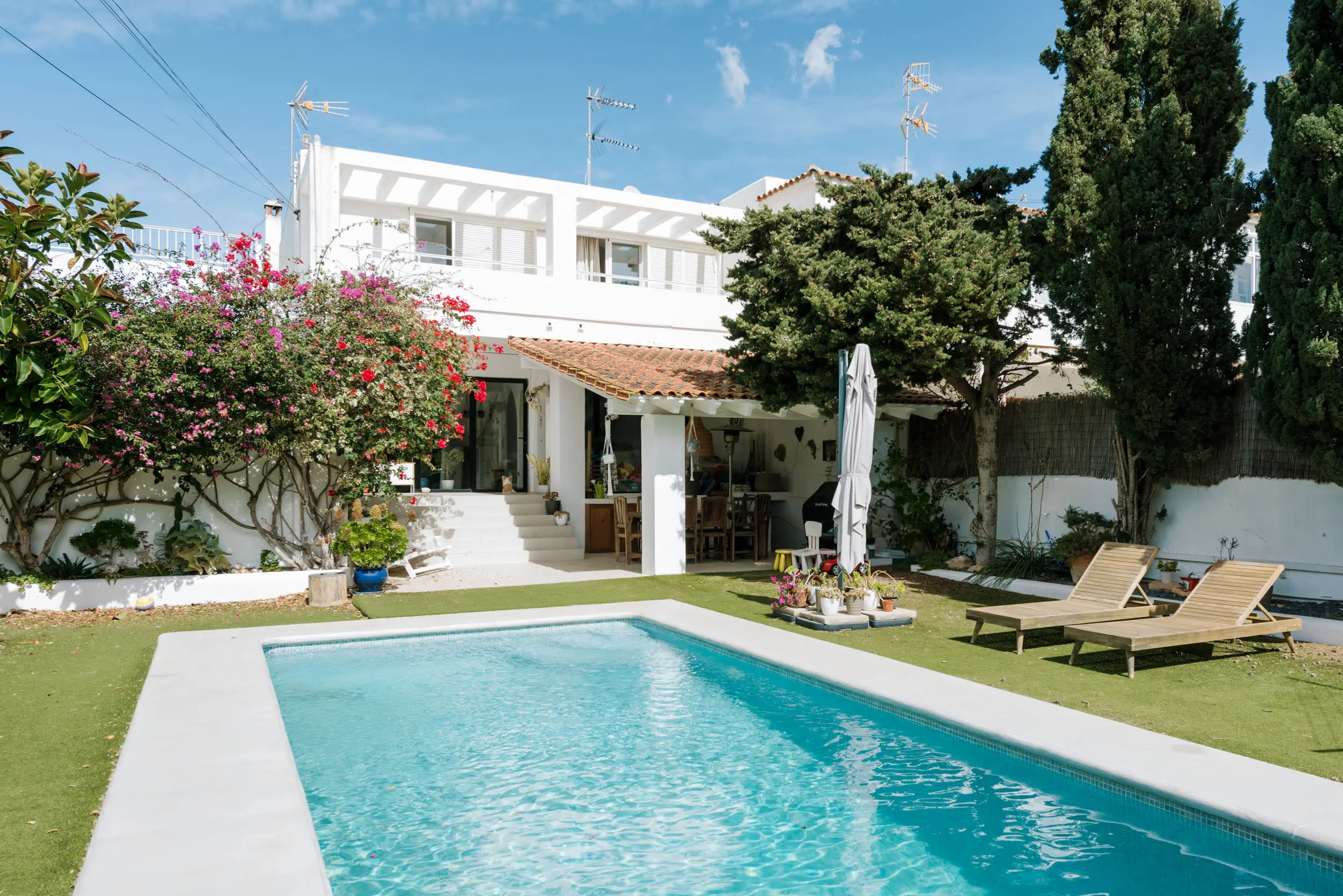 Une maison blanche avec piscine à Ibiza et son petit jardin