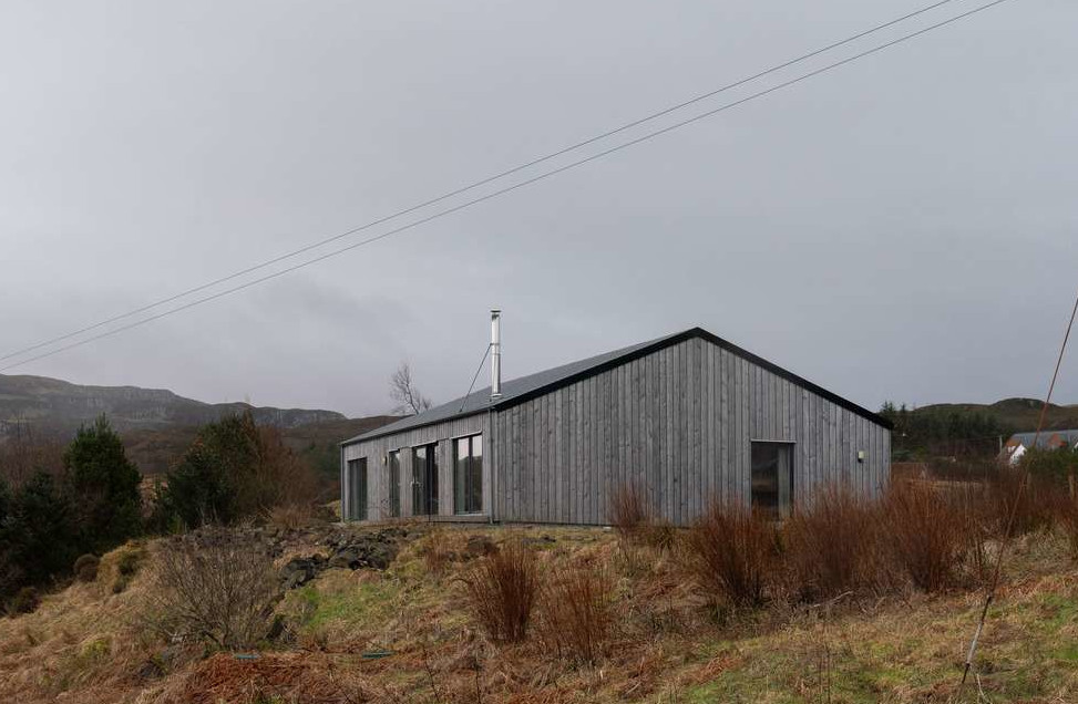 Une maison moderne en bois et sa caravane Airstream sur l’île de Skye