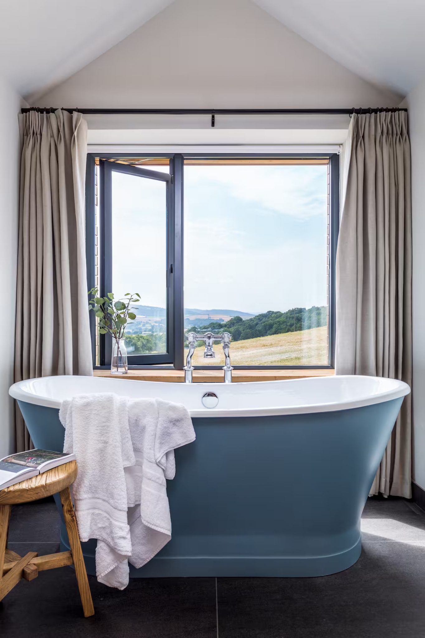 baignoire rétro bleue devant fenêtre