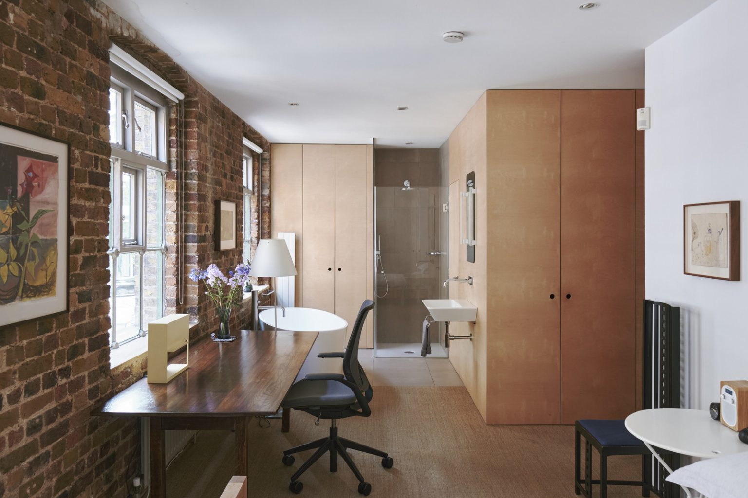 chambre avec salle de bain ouverte et murs de briques