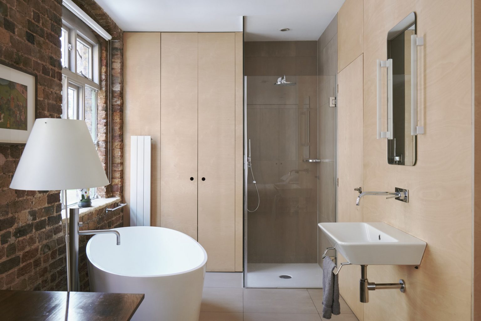 chambre avec salle de bain ouverte et murs de briques