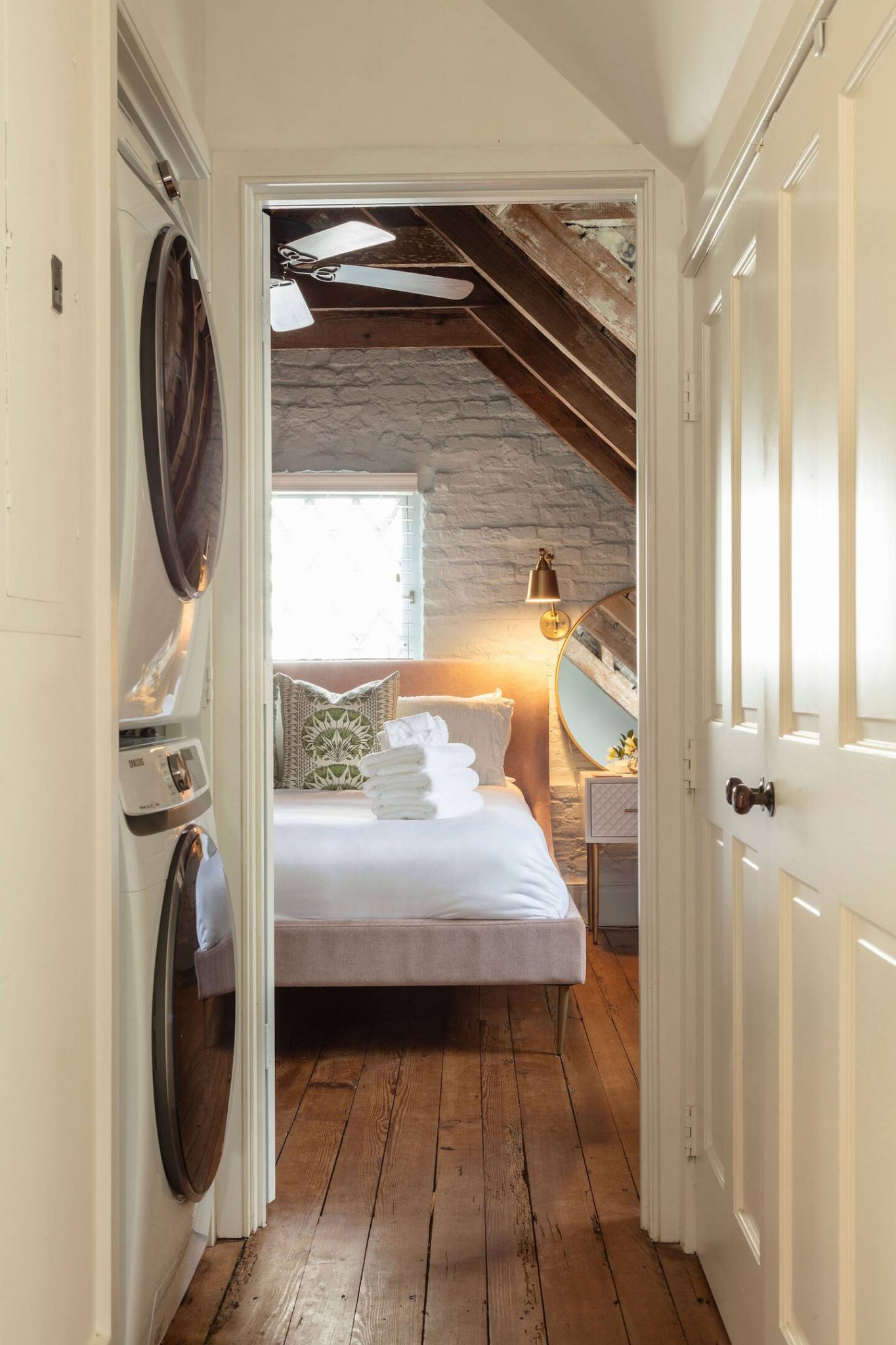 chambre mansardée avec poutres mur brique blanche