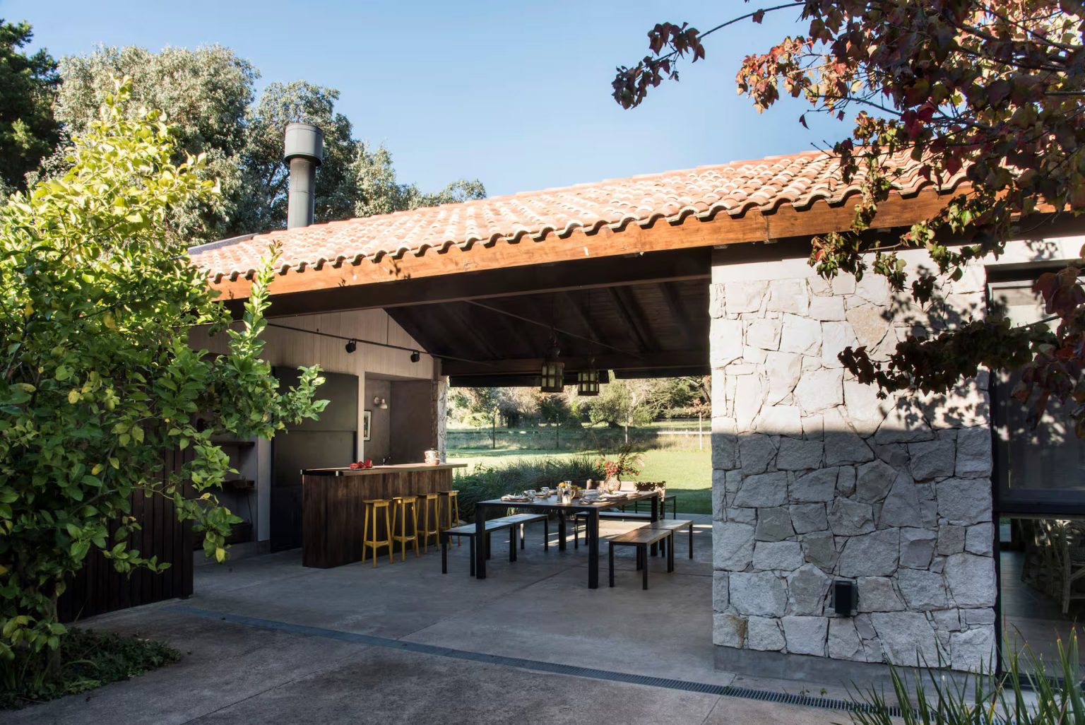 terrasse maison en pierres avec cuisine d'été et salle à manger extérieure