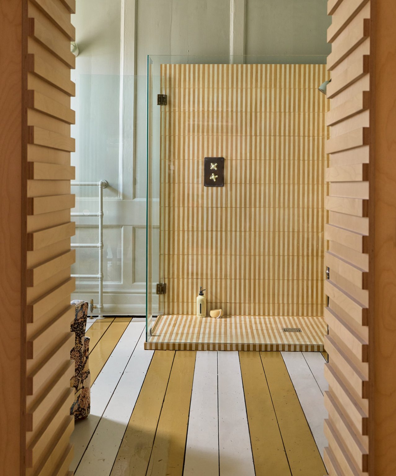 salle de bain avec douche italienne et parquet au sol bicolore