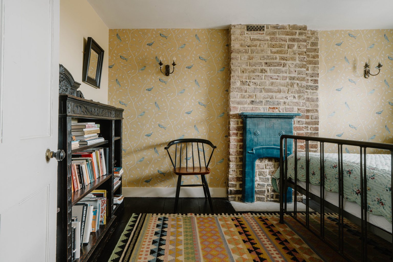 chambre avec papier-peint et mur en briques anciennes