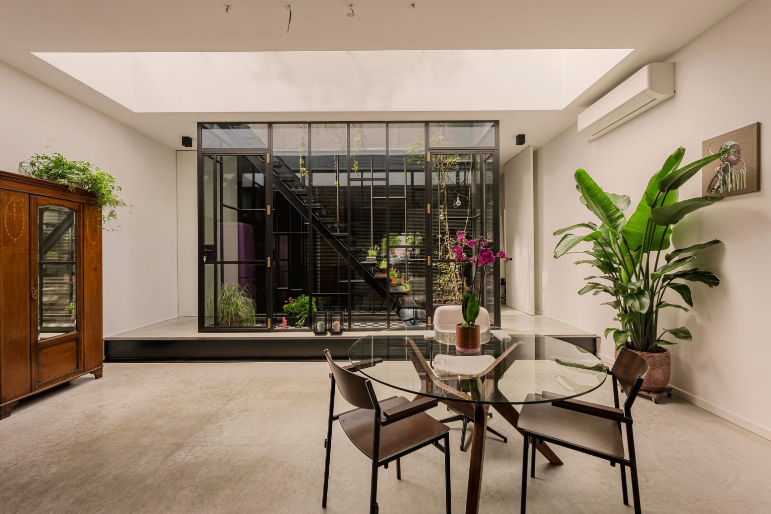 salle à manger avec fenêtre verrière sur patio décoration design loft avec terrasse