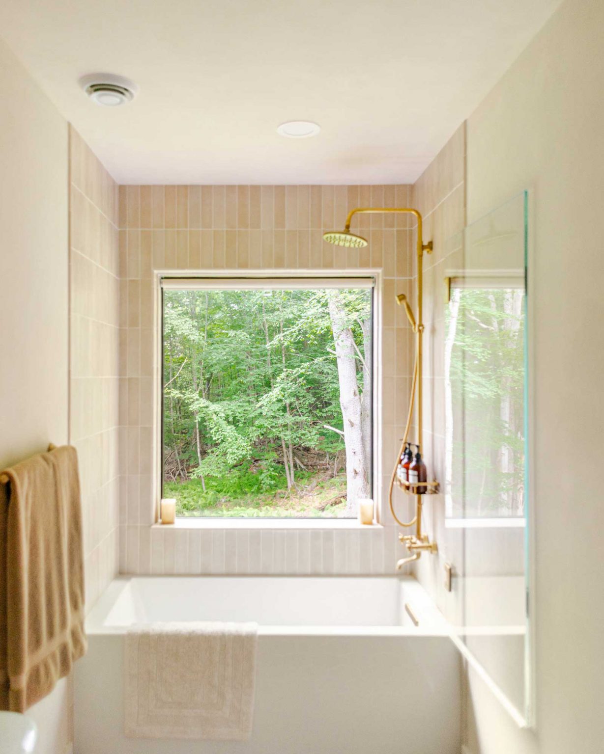 salle de bain beige avec fenêtre et baignoire