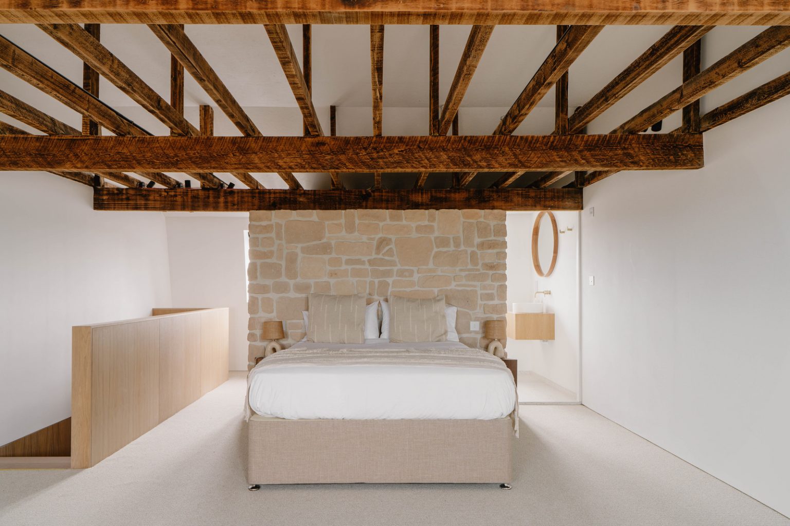 chambre avec poutres et mur de pierres décoration naturelle