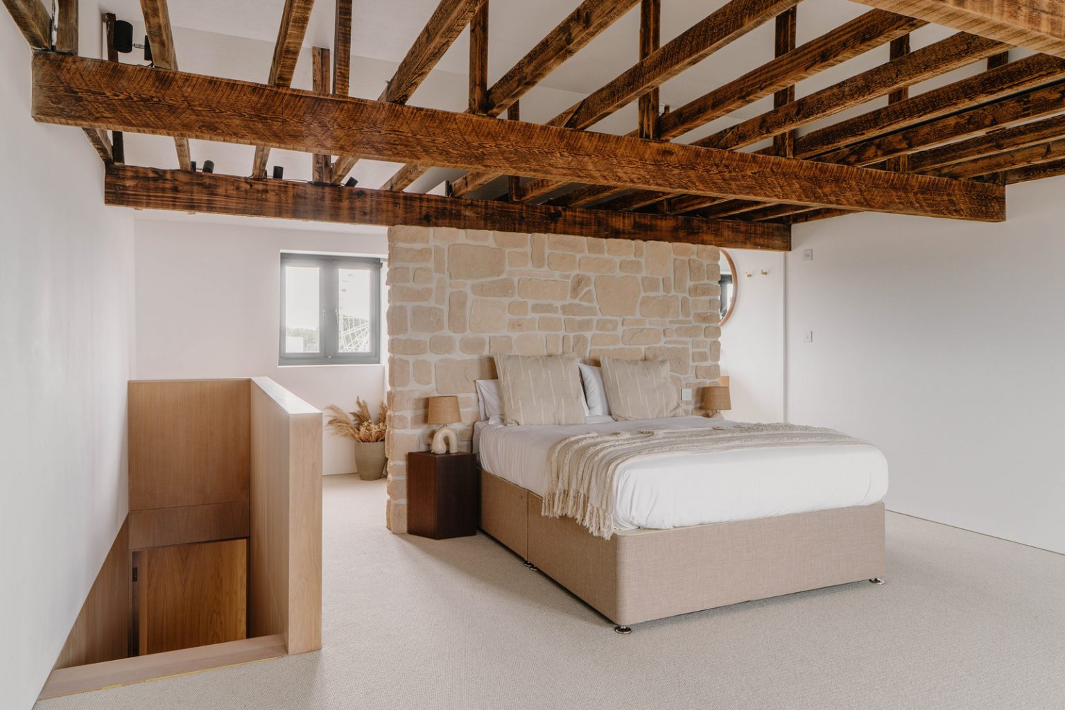 chambre avec poutres et mur de pierres décoration naturelle