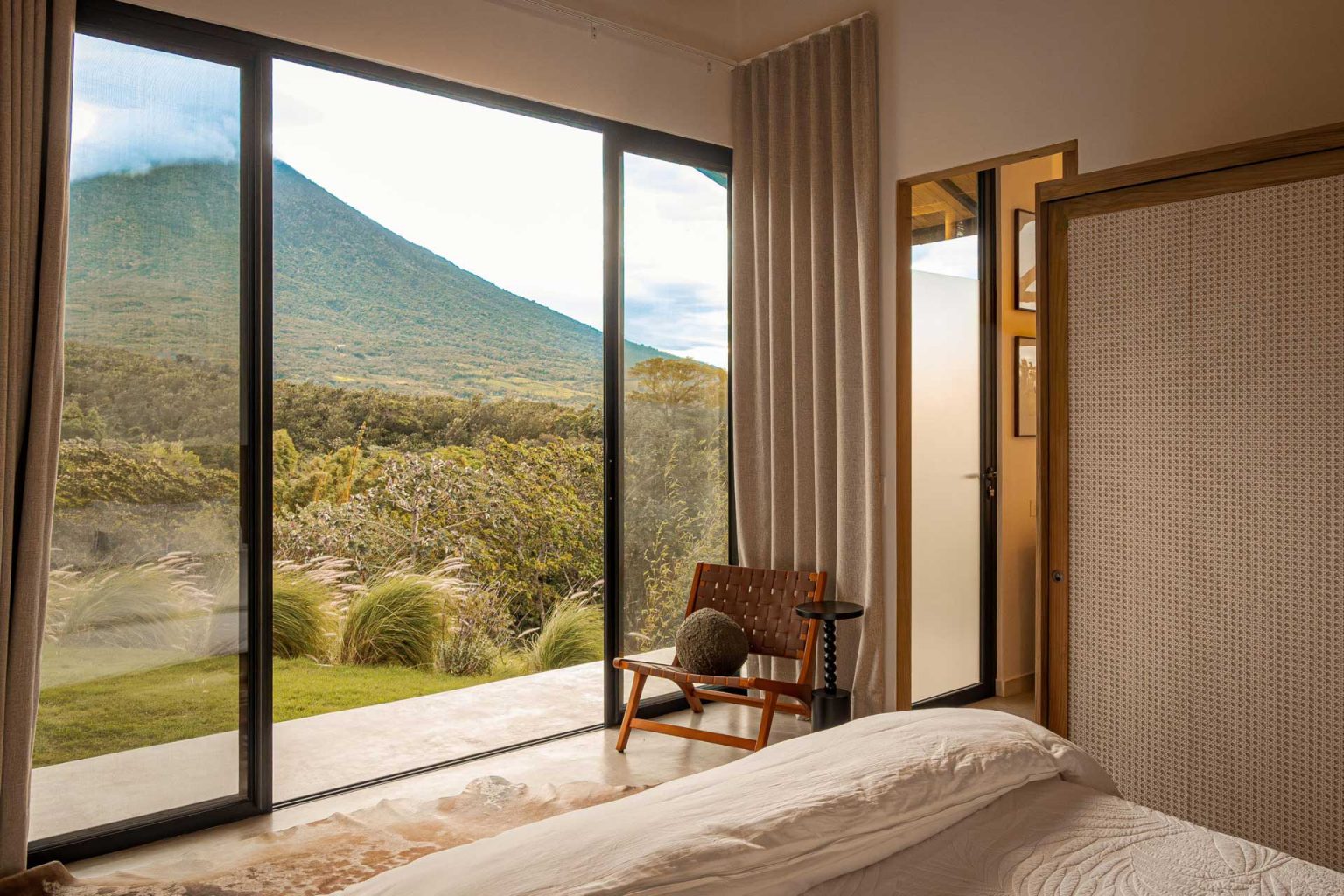 chambre décoration naturelle blanc et bois avec terrasse vue volcan