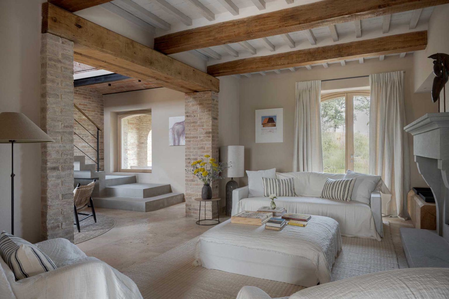 salon avec poutres et cheminée maison ancienne Italie Il Mandorlo