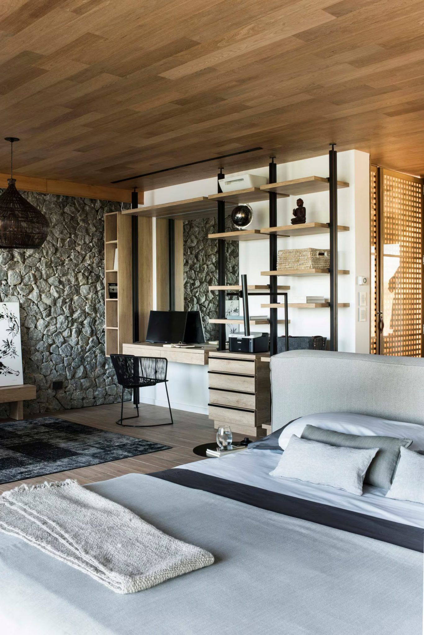 chambre avec espace bureau et mur en pierres grises