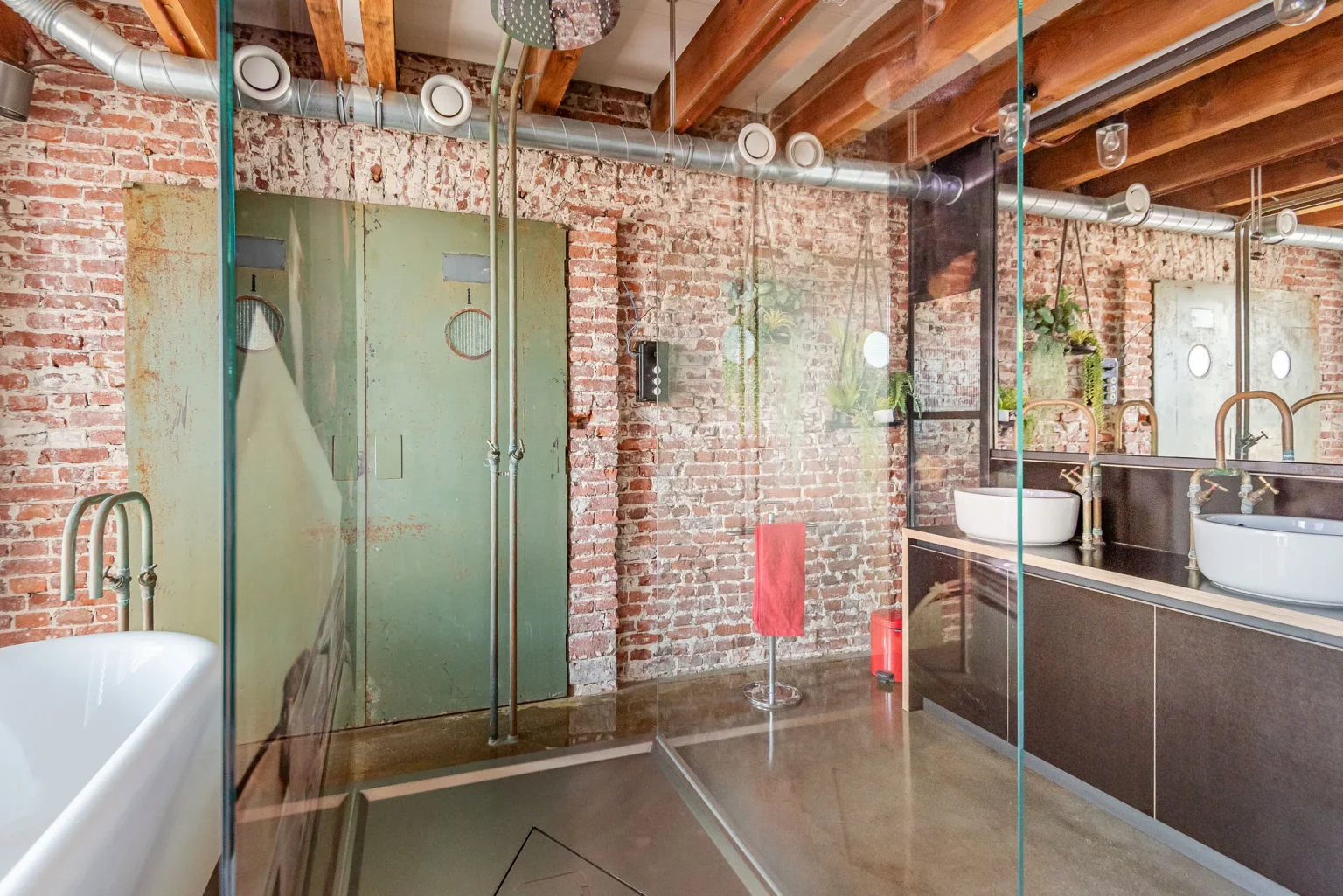 salle de bain poutres et murs briques style industriel dans ancienne usine