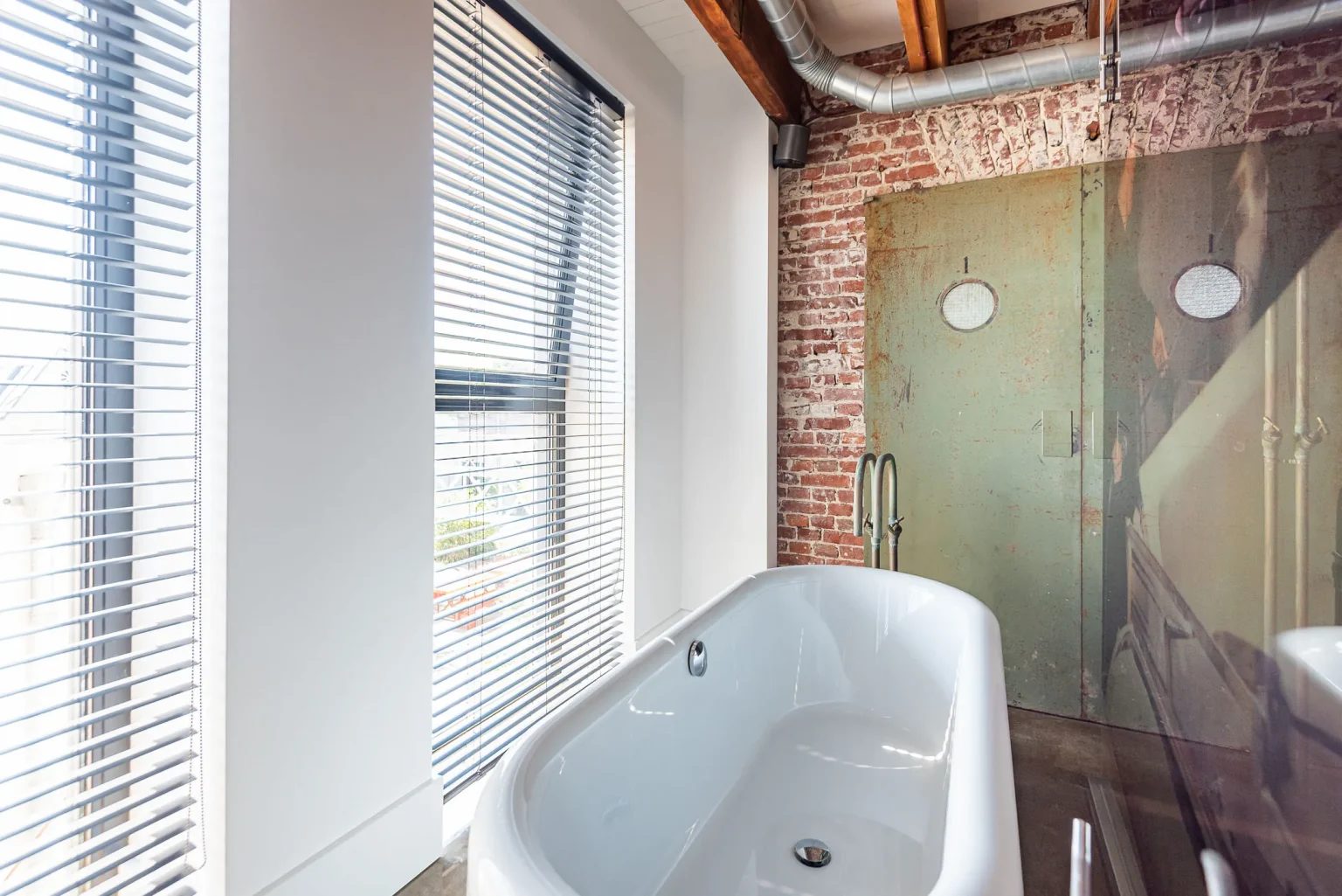 salle de bain poutres et murs briques style industriel dans ancienne usine