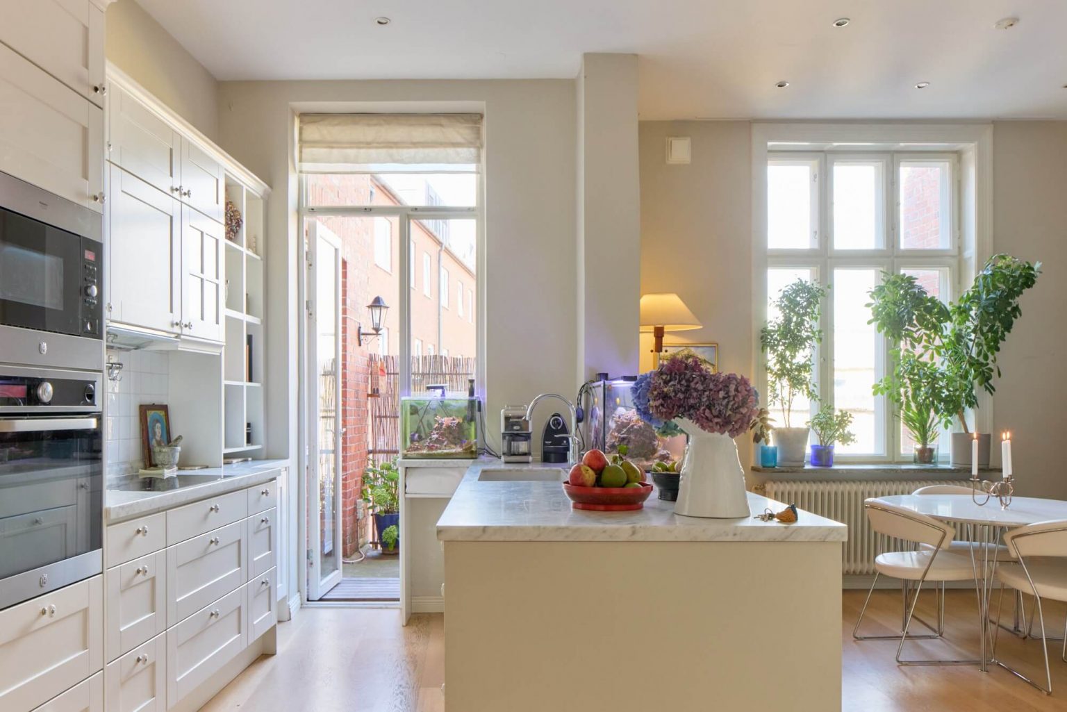 cuisine blanche et marbre avec îlot et espace repas