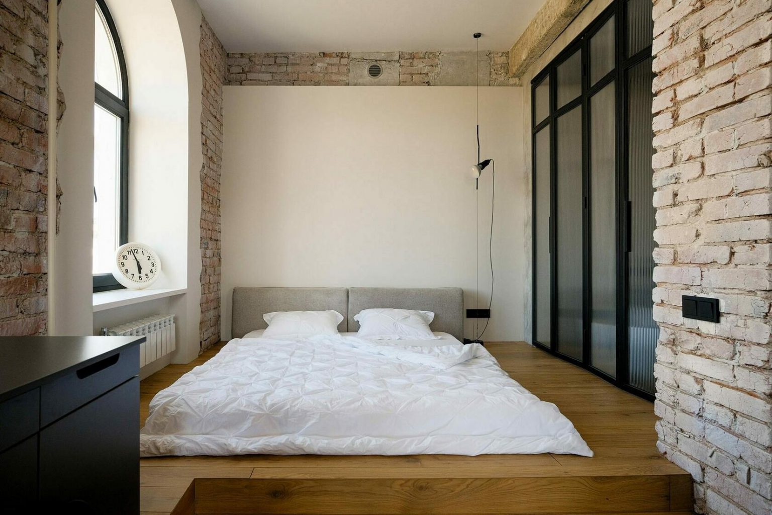 chambre avec mur verrière appartement 68m2 aux espaces ouverts style loft fenêtre cintrée murs briques