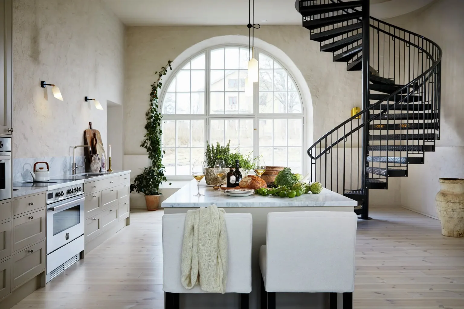 cuisine avec escalier en colimaçon et fenêtre cintrée