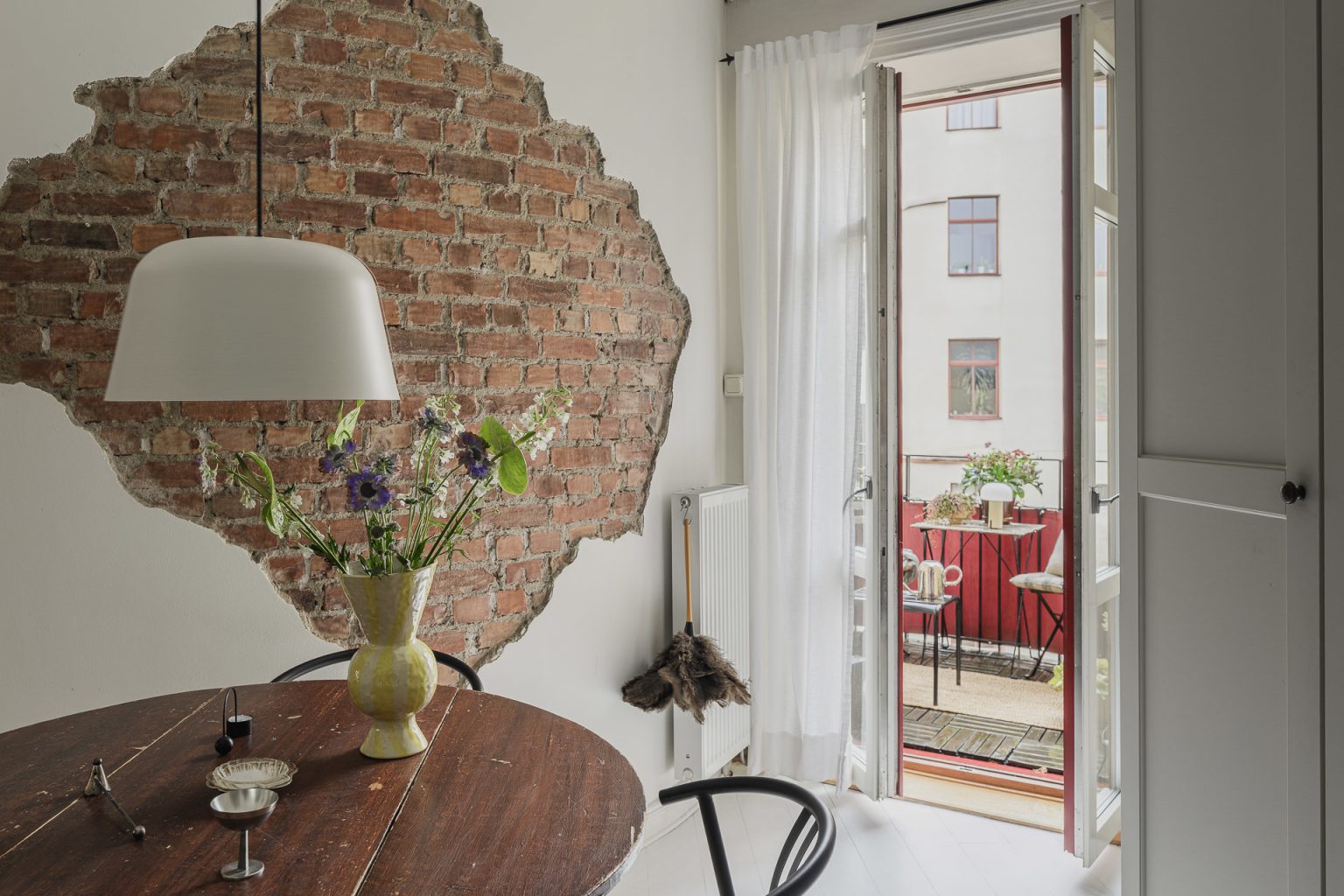 salle à manger avec mur briques anciennes et balcon