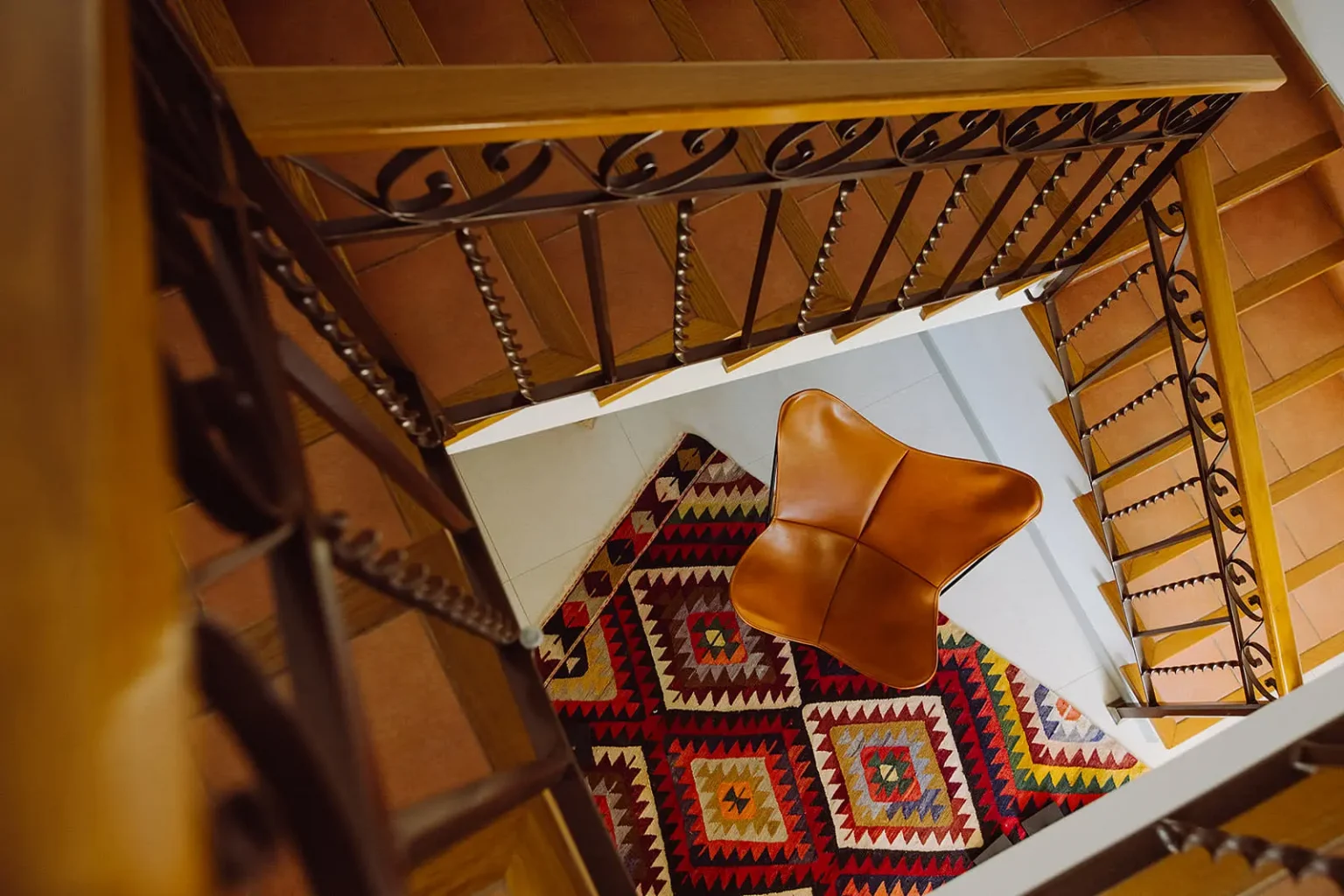 entrée avec tapis kilim et escalier bois et fer forgé maison Minorque avec piscine Can Bia