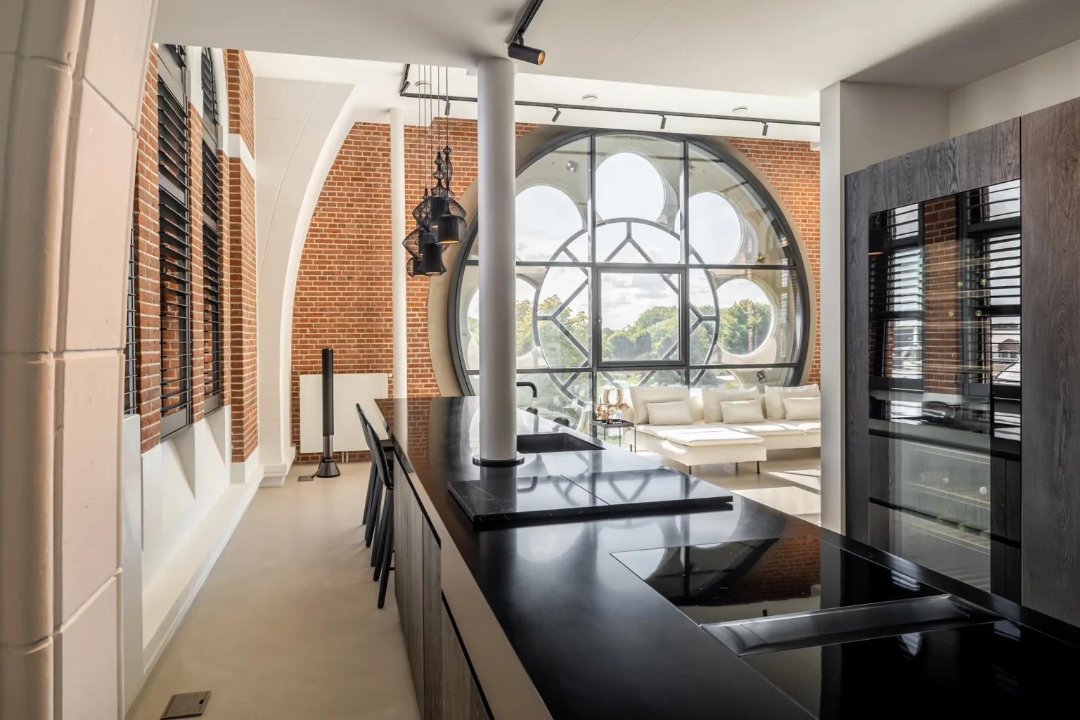 cuisine noire et salon avec baie vitrée ronde appartement design dans une ancienne église aux Pays-Bas
