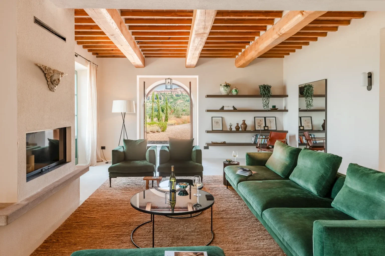 salon avec poutres et canapé vert velours maison en pierres ancienne rénovée Podere Sirolo Italie