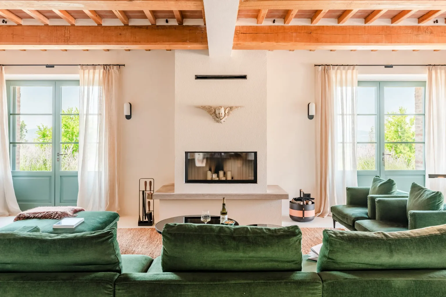 salon avec poutres et canapé vert velours maison en pierres ancienne rénovée Podere Sirolo Italie