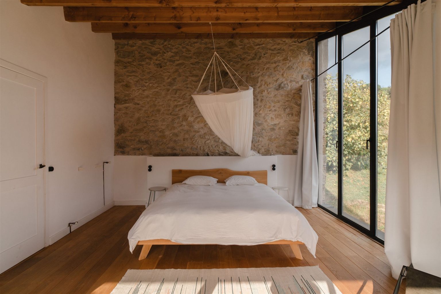 chambre avec poutres maison en pierres rénovée du 19e siècle