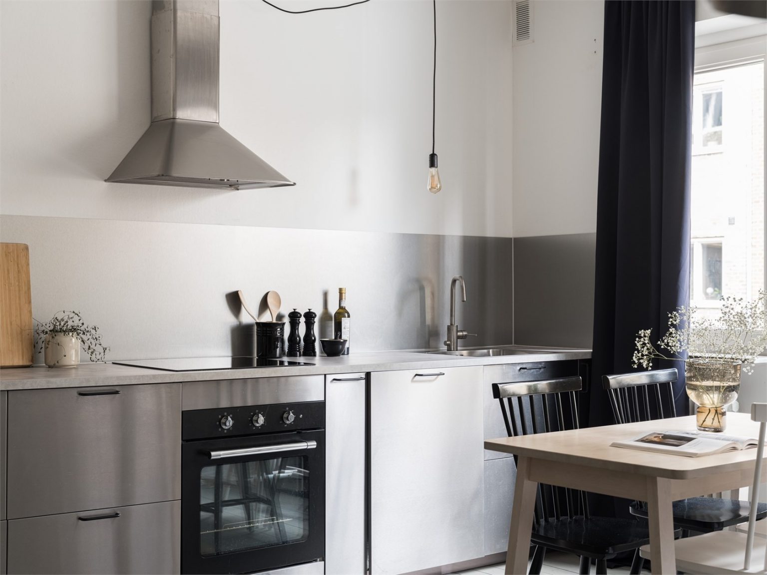 cuisine inox et espace repas studio 35m2 avec canapé velours rose 