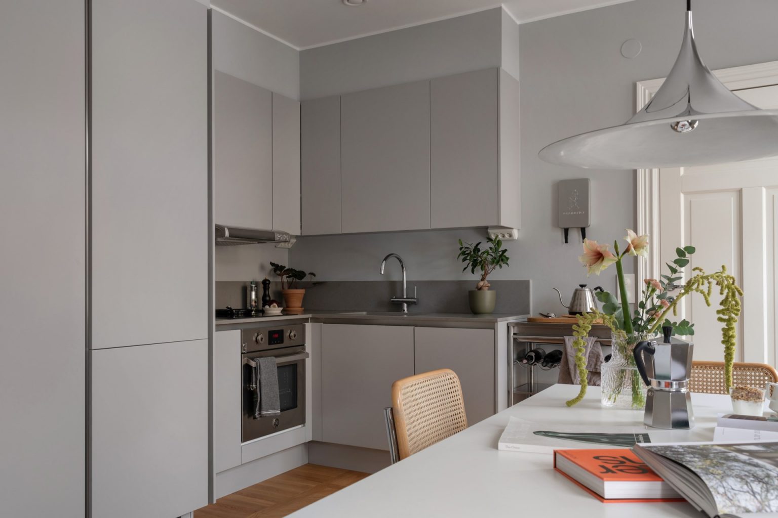 cuisine ouverte en angle design grise et espace repas studio 34m2 dans immeuble ancien décoration scandinave