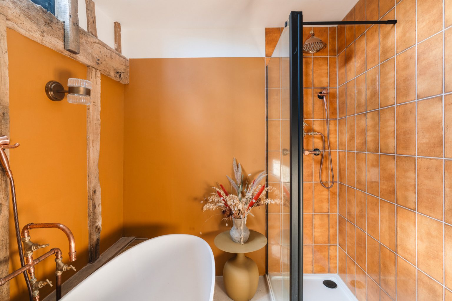 salle de bain murs orange avec colombages et poutres ancienne grange rénovée du 18e siècle