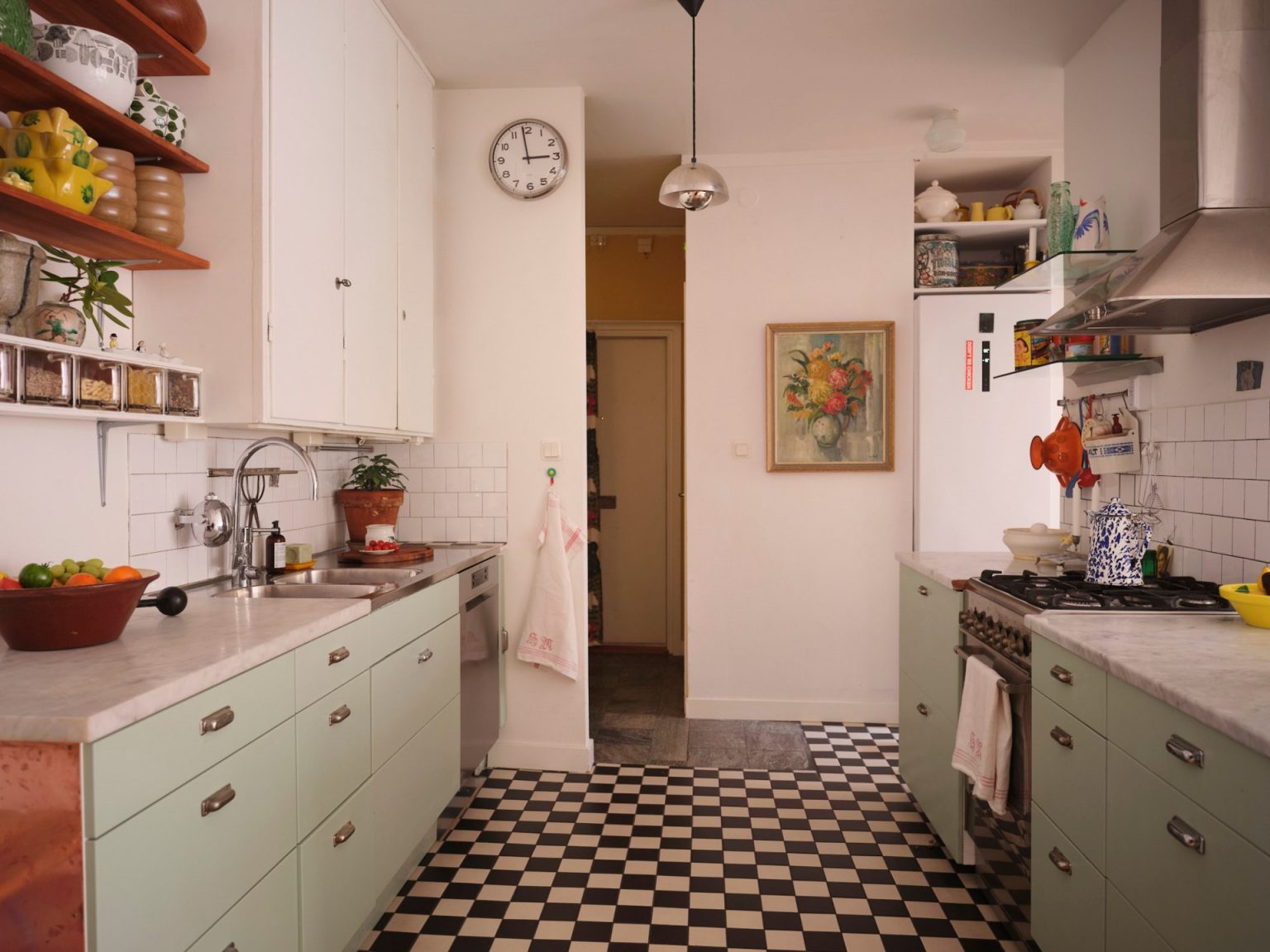 cuisine ouverte verte décoration vintage et scandinave sol à damier noir et blanc