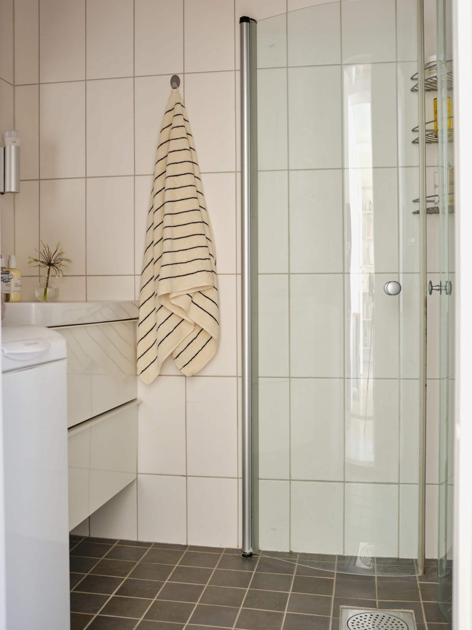 salle de bain avec douche d'angle et carrelage blanc et gris