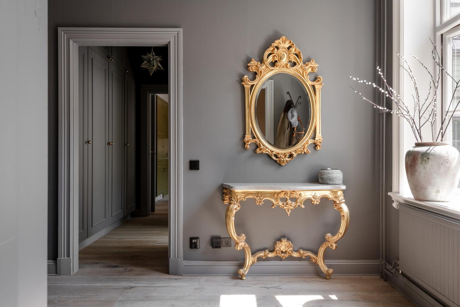 entrée murs gris avec miroir et console baroque dorés deux-pièces 66m2