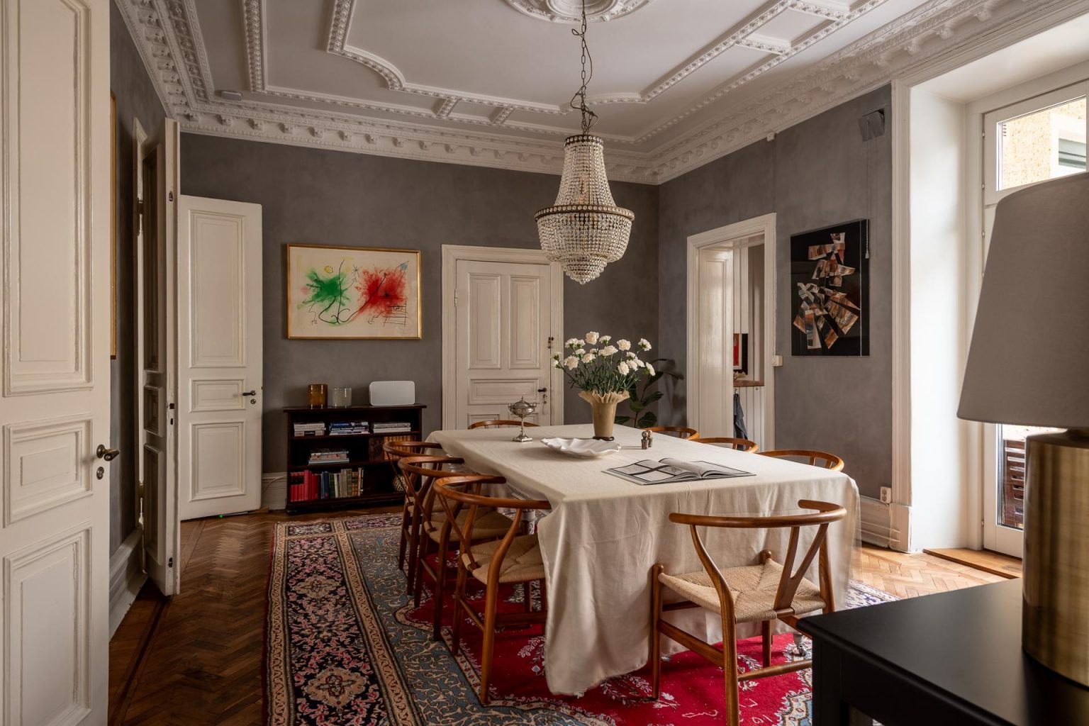 salle à manger murs gris moulures appartement type haussmannien décoration classique chic