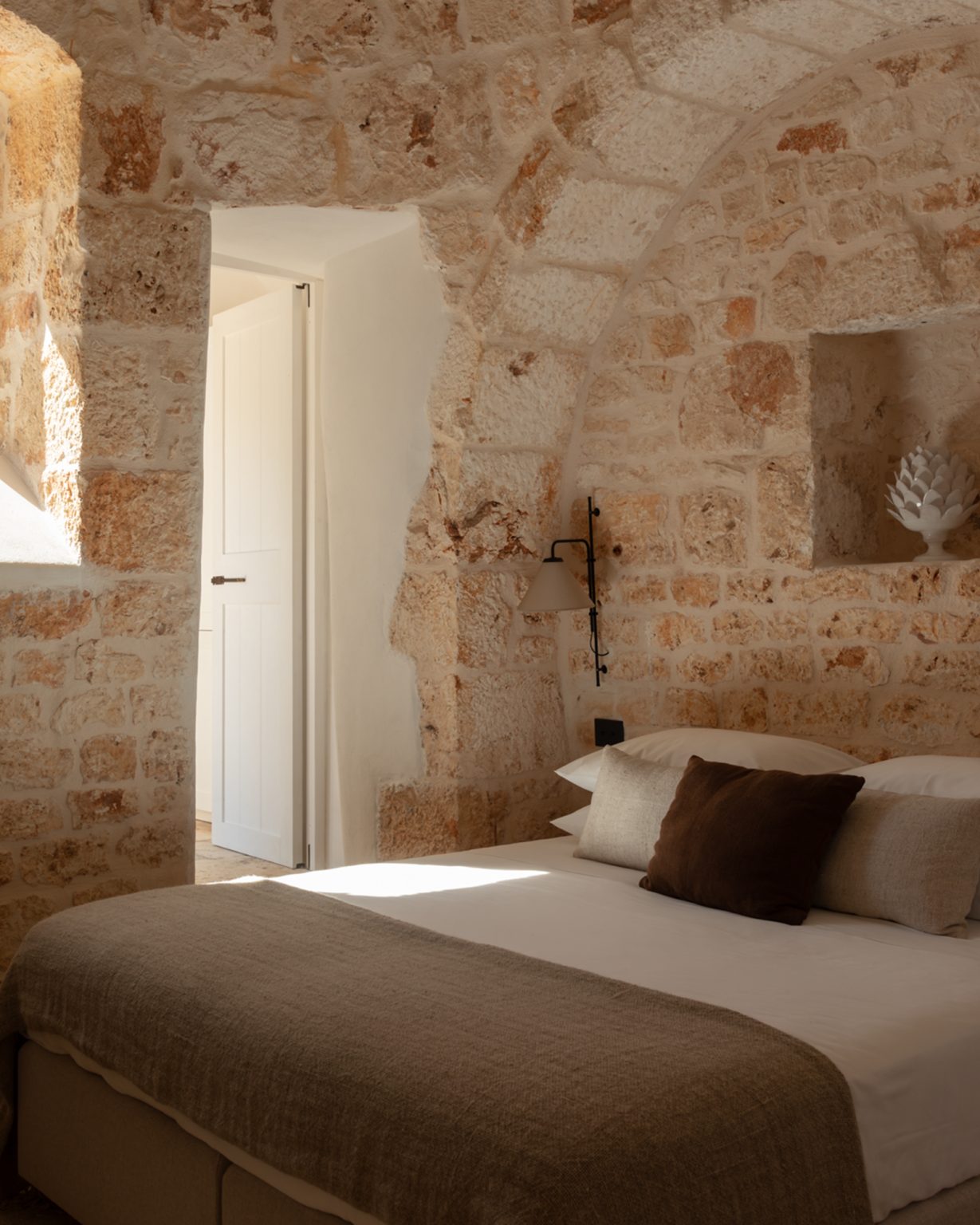 chambre avec arches en pierres maison Pouilles trulli Otto Cappelli décoration rustique chic