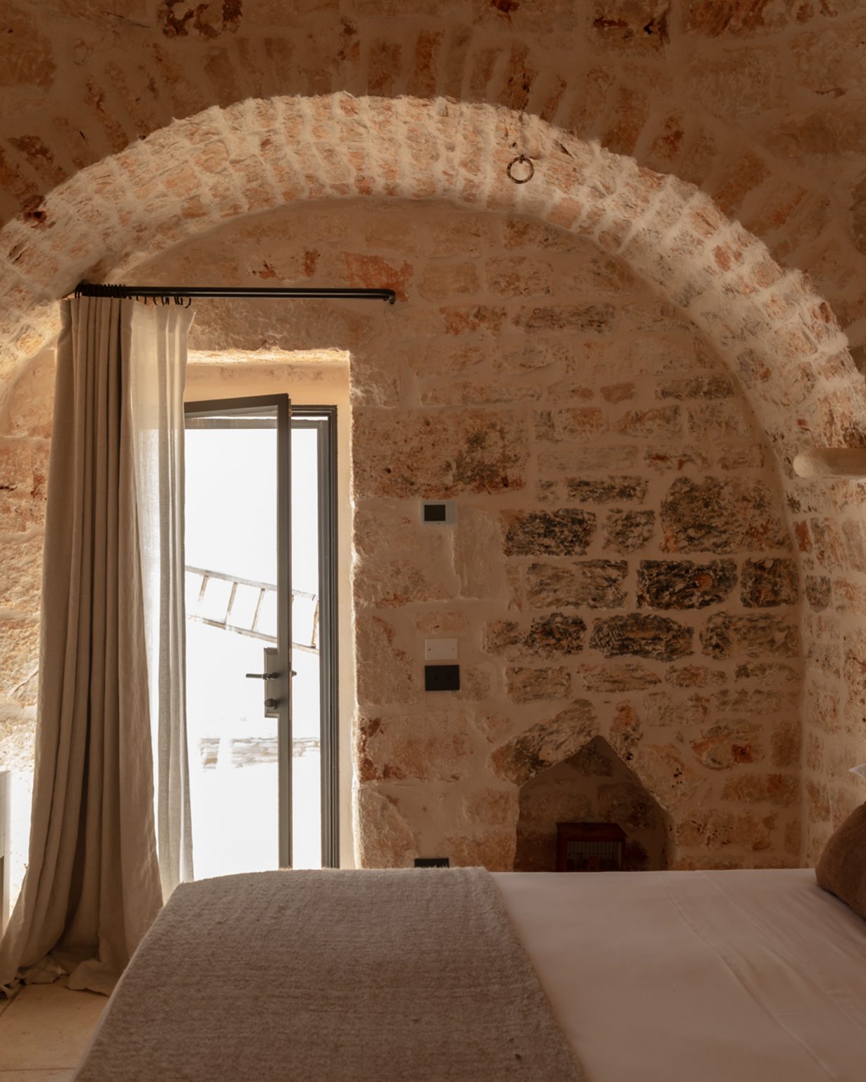 chambre avec arches en pierres maison Pouilles trulli Otto Cappelli décoration rustique chic