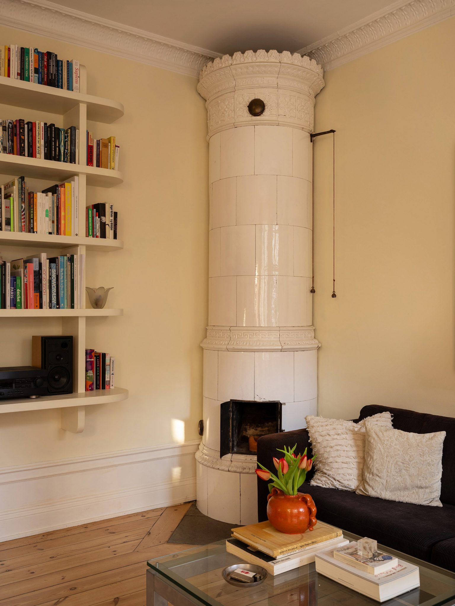 poêle ancien dans salon murs jaunes décoration scandinave appartement deux-pièces 48m2 style vintage dans immeuble du 19e siècle